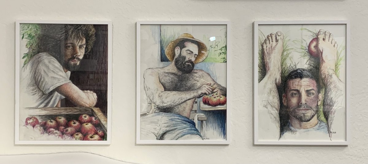 „Drei gerahmte Buntstiftzeichnungen aus der 'Apfelserie' nebeneinander an einer weißen Wand. Die Porträts zeigen bärtige Männer in unterschiedlichen Interaktionen mit roten Äpfeln – von der Ernte über das Schälen bis hin zu einer verspielten Szene im Gras.“